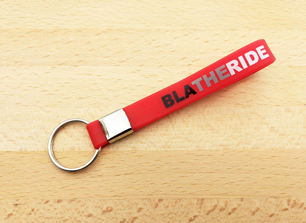 Porta-chaves de silicone personalizado de cor vermelha, com texto nas cores preto, cinzento e branco